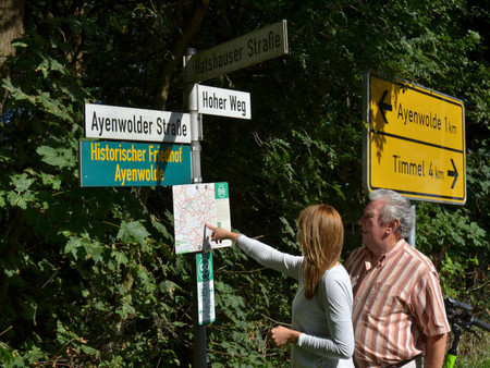 Zwei Personen stehen am Knotenpunktschild 