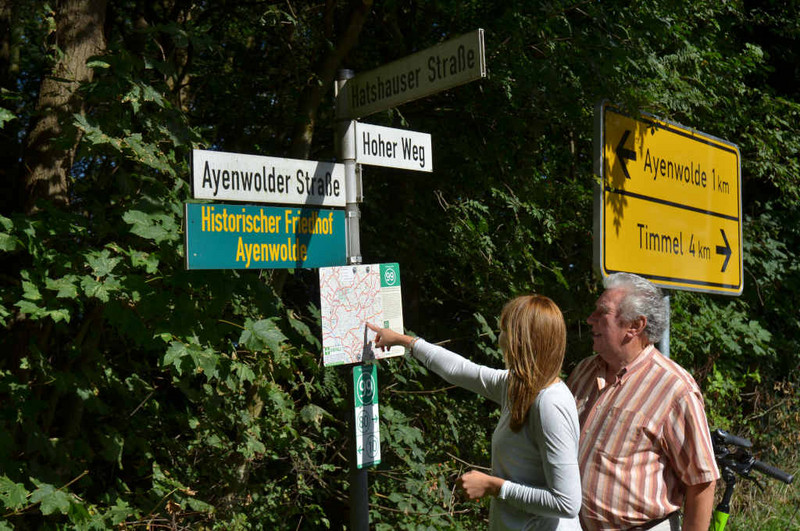 Zwei Personen stehen am Knotenpunktschild 