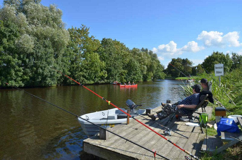 Angler am Bootssteg am Rorichumer Tief, Kanufahrer im Hintergrund